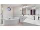 Spacious main bathroom with a soaking tub, large mirror, and white cabinets at 201 Shady Lane Dr, Smithfield, NC 27577