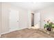 Bedroom featuring light-colored walls, carpet, and two doors; brightened by an indoor plant at 2040 Alderman Way, Creedmoor, NC 27522