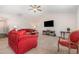 Bright living room boasts plush red sofa, ceiling fan, and a TV above a decorative fireplace at 2040 Alderman Way, Creedmoor, NC 27522