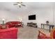 Bright living room boasts plush red sofa, ceiling fan, and a TV above a decorative fireplace at 2040 Alderman Way, Creedmoor, NC 27522