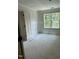Unfinished bedroom with ample natural light from the window, complemented by a closet and clean white walls at 207 S Main St # A, Four Oaks, NC 27524
