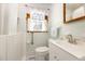 Bright bathroom featuring blue and white tile, a vanity, and a window with white curtains at 2129 Wrenn St, Burlington, NC 27215