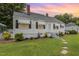 Charming home with manicured landscaping, white exterior paint, awnings, and a inviting entrance at 2129 Wrenn St, Burlington, NC 27215
