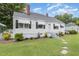 Charming home with manicured landscaping, white exterior paint, awnings, and a inviting entrance at 2129 Wrenn St, Burlington, NC 27215