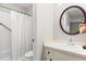 Bright bathroom featuring a shower with curtain, a vanity with a round mirror, and neutral-toned walls at 232 Clancy Cir, Cary, NC 27511