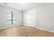Bright bedroom featuring a large window, hardwood floors, and closet space for storage and organization at 232 Clancy Cir, Cary, NC 27511
