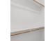 A simple reach-in closet featuring white walls and shelving with wooden closet rods at 232 Clancy Cir, Cary, NC 27511