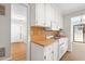 Kitchen showcasing white cabinets, hardwood floors, modern appliances, and access to the dining and living areas at 232 Clancy Cir, Cary, NC 27511