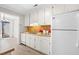 Cozy kitchen featuring white cabinets, updated appliances, hardwood floors, and backyard access at 232 Clancy Cir, Cary, NC 27511