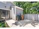 An exterior view of a backyard patio with sliding glass doors, trash receptacles and privacy fence at 232 Clancy Cir, Cary, NC 27511