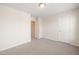 Empty bedroom featuring neutral carpeting, standard ceiling fixture, and standard doors at 236 Lynchwick Ln, Durham, NC 27703
