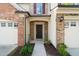 Close-up of front door with brick and siding, plus well-maintained landscaping at 236 Lynchwick Ln, Durham, NC 27703