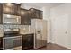 Modern kitchen with stainless steel appliances, granite countertops, and dark cabinets at 236 Lynchwick Ln, Durham, NC 27703