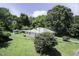 This charming home is surrounded by mature trees and an outbuilding, set on a spacious lot near other houses at 310 Spring St, Durham, NC 27703