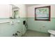 Bathroom features light-green tiling and window for natural lighting at 310 Spring St, Durham, NC 27703