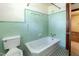 Bathroom features light-green tiling, a bath tub and matching toilet at 310 Spring St, Durham, NC 27703