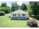 A charming single-story home with a covered front porch, and a spacious yard surrounded by mature trees at 310 Spring St, Durham, NC 27703