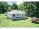 A charming single-story home with a covered front porch, and a spacious yard surrounded by mature trees at 310 Spring St, Durham, NC 27703