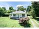 Charming single-story home featuring a covered front porch, white siding, neatly trimmed shutters, and a spacious yard at 310 Spring St, Durham, NC 27703