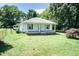 A charming single-story home with a covered front porch, and a spacious yard surrounded by mature trees and an outbuilding at 310 Spring St, Durham, NC 27703