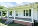 This home's covered porch features sturdy support columns and dark green shutters to accent this charming home at 310 Spring St, Durham, NC 27703