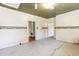 Large room with damaged floor, wallpaper and access to two other rooms at 310 Spring St, Durham, NC 27703