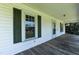 White home's covered front porch featuring wood flooring, white railings, and a front entrance at 310 Spring St, Durham, NC 27703