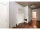 A room with hardwood flooring, white trim, and a textured ceiling with access to multiple rooms at 310 Spring St, Durham, NC 27703