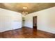 Spacious room featuring hardwood floors, textured ceiling, fireplace, and access to other rooms at 310 Spring St, Durham, NC 27703