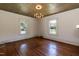 Empty room featuring hardwood floors, textured ceiling, and natural light from two windows at 310 Spring St, Durham, NC 27703