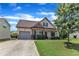 Well-kept home featuring a two-car garage, inviting porch, and green lawn for outdoor enjoyment at 3106 Royal Deeside Ct, Zebulon, NC 27597