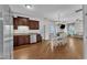 Open-concept kitchen featuring hardwood floors, stainless steel appliances, adjacent dining area, and seamless flow to the living room at 3106 Royal Deeside Ct, Zebulon, NC 27597