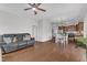 A view of the living room with hardwood floors and ceiling fan connecting the kitchen and dining area at 3106 Royal Deeside Ct, Zebulon, NC 27597