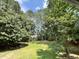 Beautiful lush backyard featuring mature trees, landscaping, and ample green space at 3212 Potthast Ct, Raleigh, NC 27529