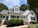 Charming two-story home with a white exterior, dormer, and inviting front porch at 3212 Potthast Ct, Raleigh, NC 27529