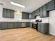 Modern kitchen featuring sleek gray cabinets, stainless steel appliances, and light wood flooring at 3212 Potthast Ct, Raleigh, NC 27529