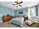 Well-lit bedroom with a ceiling fan, a comfortable bed, and a seating area by the window with natural light at 322 Tobacco Farm Way, Chapel Hill, NC 27516