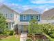 Charming two-story blue home with a yellow door, front porch, and landscaped front yard at 322 Tobacco Farm Way, Chapel Hill, NC 27516