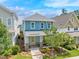 Charming two-story blue home with a yellow door, front porch, and landscaped front yard at 322 Tobacco Farm Way, Chapel Hill, NC 27516