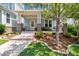 Inviting front porch with seating and a yellow door, enhanced by lush landscaping at 322 Tobacco Farm Way, Chapel Hill, NC 27516