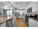 Bright kitchen features white cabinets, stainless steel appliances, and hardwood floors at 322 Tobacco Farm Way, Chapel Hill, NC 27516