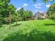 Large, green backyard with mature trees and glimpses of the house at 3581 Boulder Ct, Wake Forest, NC 27587