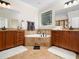 Bright bathroom featuring a tiled tub, double vanity, and large window providing natural light and a serene view at 3581 Boulder Ct, Wake Forest, NC 27587