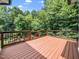 View of a stained deck with stairs leading down to the lush backyard at 3581 Boulder Ct, Wake Forest, NC 27587