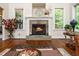 Cozy fireplace with stone surround, flanked by windows with leafy green views at 3581 Boulder Ct, Wake Forest, NC 27587