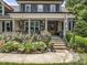 Inviting front porch with stone accents, classic columns, and an American flag waving in the breeze at 3581 Boulder Ct, Wake Forest, NC 27587