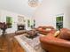 Living room featuring leather sofas, wood flooring, fireplace and natural lighting at 3581 Boulder Ct, Wake Forest, NC 27587
