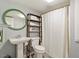 Clean bathroom features a pedestal sink, modern fixtures, shower, and unique mirror at 4404 Oak Park Rd, Raleigh, NC 27612
