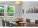 Bright dining room with modern decor, large windows, and a view of the outdoor greenery at 4404 Oak Park Rd, Raleigh, NC 27612