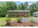 Charming two-story home with brick and vinyl siding, an orange door and a well-manicured lawn at 4404 Oak Park Rd, Raleigh, NC 27612